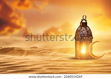 Ornamental Arabic lantern with burning candle glowing . Festive greeting card, invitation for Muslim holy month Ramadan Kareem. Ramadan Kareem greeting photo with serene mosque background.
 Royalty-Free Stock Photo #2260514269
