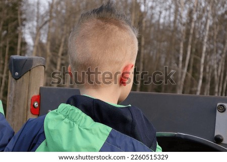 Child with cool haircut. Photo from behind. Selective focus. Stockholm, Sweden,  January 2023.