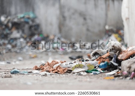 Landfill site, a pile of stinky different junk disposal in the concrete section for unsorted waste materials Royalty-Free Stock Photo #2260530861