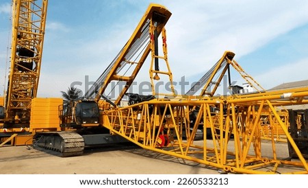 Two big yellow crawler crane assembling the boom and setting up. Royalty-Free Stock Photo #2260533213