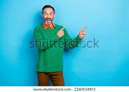 Portrait of cheerful astonished person direct fingers empty space offer isolated on blue color background