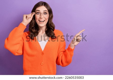 Photo of excited funny business lady wear orange shirt eyeglasses surprised point finger mockup new brand deal isolated on purple color background