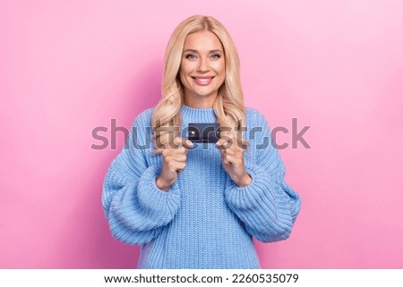 Photo of positive toothy beaming nice woman with curly hairstyle wear blue sweater hold plastic card isolated on pink color background