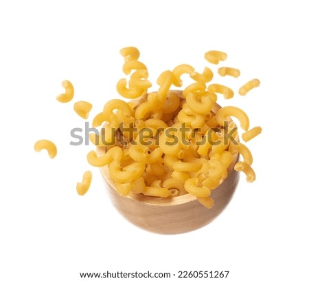 Macaroni fall on wooden bowl, yellow macaronis pasta float explode, abstract cloud fly. Curved macaroni pasta splash throwing in Air. White background Isolated high speed shutter, freeze motion Royalty-Free Stock Photo #2260551267