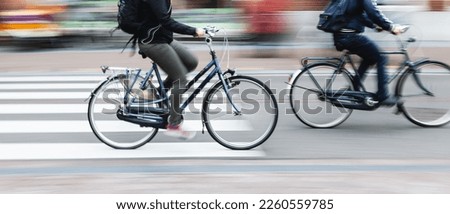 picture with camera made motion blur effect of bicycle riders on a city street