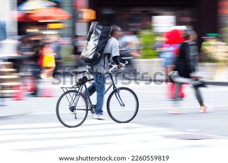 picture with camera made motion blur of a bicycle messenger on the move in the city