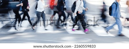 picture with motion blur of crowds of people who crossing a city street