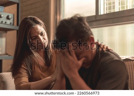 A concerned wife comforts her husband who breaks down and cries. Being there for a partner during hard times. Royalty-Free Stock Photo #2260566973