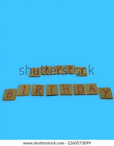selective focus of the red alphabet and numbers on the brown cardboard with a blue background in a certain order. it forms the text welcome to HAPPY BIRTHDAY