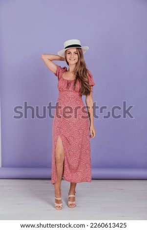 blonde in hat poses on a purple background