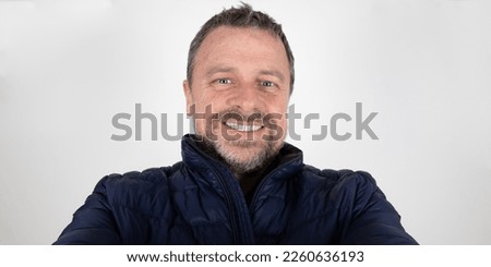 Man handsome smiling looking camera cell phone smartphone for selfie on white background