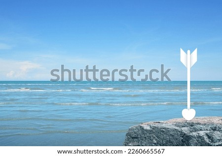 Love heart dart Icon on rock mountain over tropical sea and blue sky, Valentines day concept