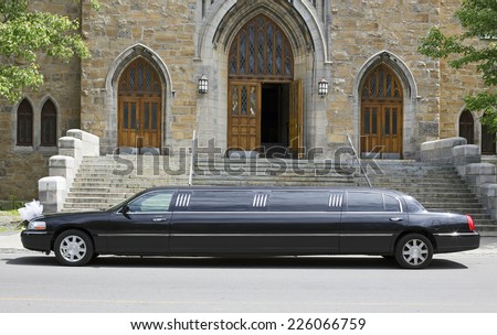 Luxury black limousine awaiting in front of a church Royalty-Free Stock Photo #226066759