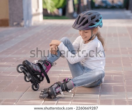 Kid stand with bottle of water, Child helmet for rollers, pretty little girl learning to roller skate, Happy girl, 
