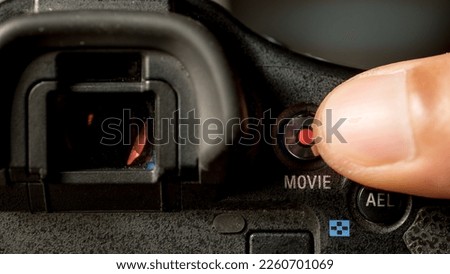 close-up photo of someone's thumb about to press the record button on the camera. concept about film and videography, creator content