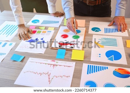 Two business person working on the office desk with business graphs