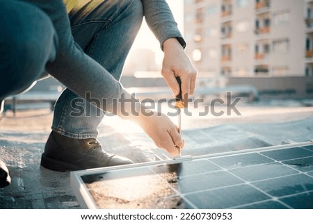 Solar panel, screwdriver and worker hands with tools for renewable energy and electricity. Sustainable innovation, roof work and engineering employ install eco friendly and sustainability product Royalty-Free Stock Photo #2260730953