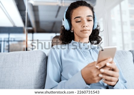 Phone, music headphones and business woman on sofa in office streaming audio. Cellphone, relax technology and female employee on couch listening to podcast, radio or sound with mobile smartphone.