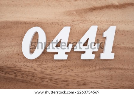 White number 0441 on a brown and light brown wooden background.