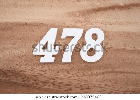 White number 478 on a brown and light brown wooden background. Royalty-Free Stock Photo #2260734631