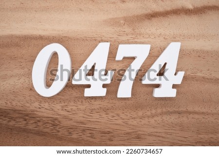 White number 0474 on a brown and light brown wooden background.