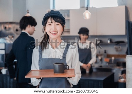 Cafe staff working with a smile Royalty-Free Stock Photo #2260735041