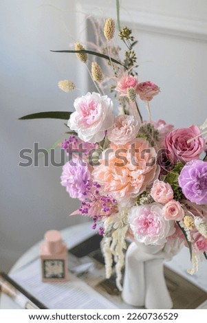 Trendy Ceramic Vase of human head. Bunch of flowers in vase in shape of womens face. Royalty-Free Stock Photo #2260736529