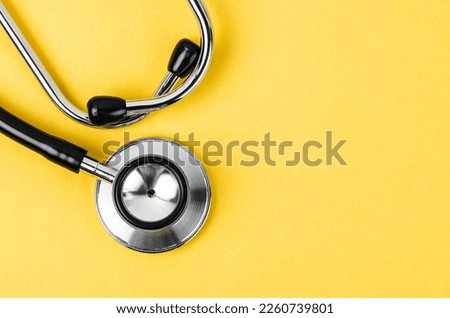 Stethoscope on yellow background with empty space for your text.