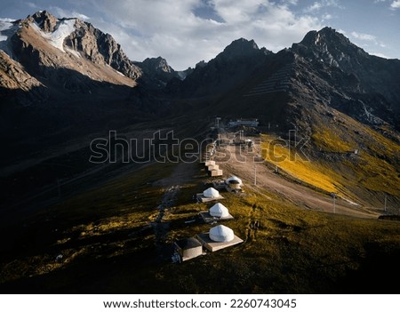 Aerial panorama landscape of the mountain valley with glacier and yurt resort at Skymbulak in Almaty, Kazakhstan. Outdoor and hiking concept