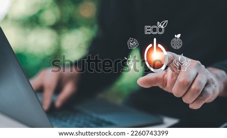 Man uses his finger to press button to turn off, closed, shut down laptop computer on desk, before going home for saving energy, save global environment. reduce global warming. world environment day Royalty-Free Stock Photo #2260743399