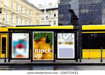 street mock-up ad sign. lightbox at tram stop. urban background. billboard sample image for mockup and place holder. advertising background. glass aluminum structure. urban scene. yellow streetcar.