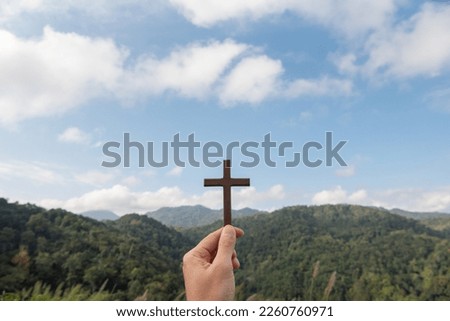 Girl praying with cross in nature sunrise background, Symbol of Faith