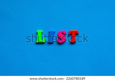 text list from plastic colored letters on blue paper background	