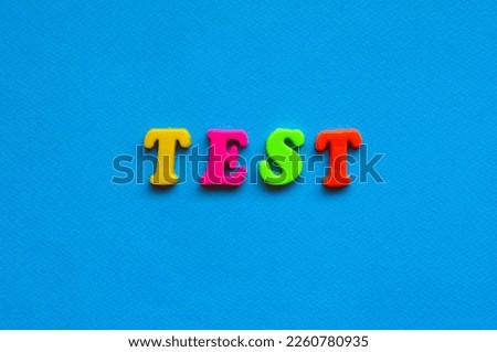 text test from plastic colored letters on blue paper background	