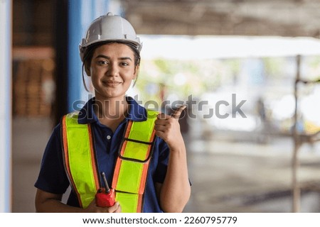 Indian woman staff worker engineer supervisor in safety suit work in factory warehouse