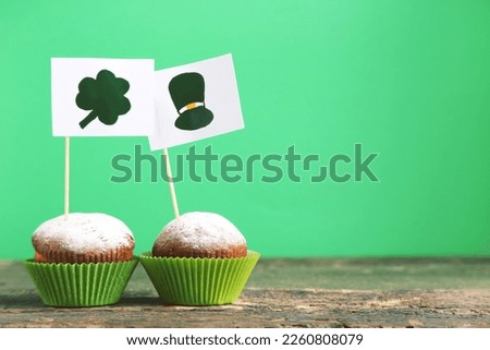 Cupcakes and flags with picture of hat and clover leaf on green background