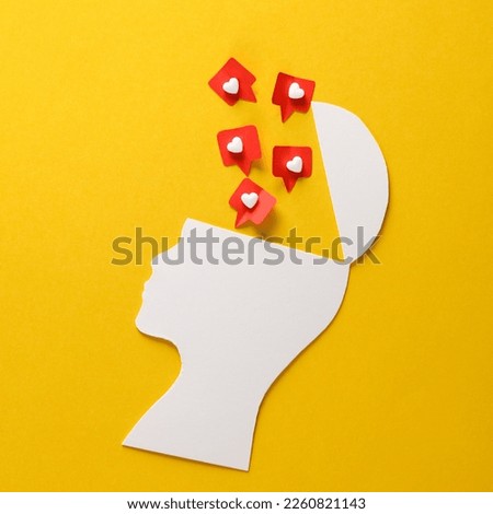 Paper cut head silhouette with likes on yellow background. Social Media Addiction
