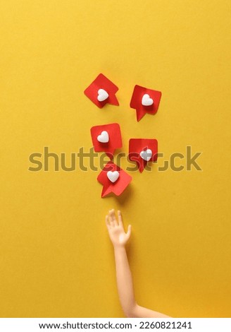 Doll's hand with Social media likes on yellow background. Creative minimal layout