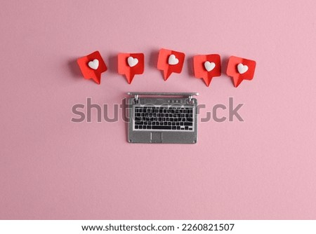 Miniature laptop with Social media likes on pink background. Creative minimal layout