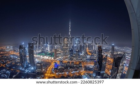 Aerial view of tallest towers in Dubai Downtown skyline and highway night  panorama. Financial district and business area in smart urban city. Skyscraper and high-rise buildings
