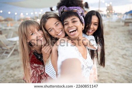 Group of girls taking selfie picture smiling at camera - Young girls celebrating standing outside and having fun at beach party 