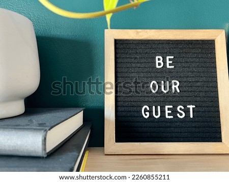 Decorative wooden shelf with changeable felt letter board with Be our guest written on it. 