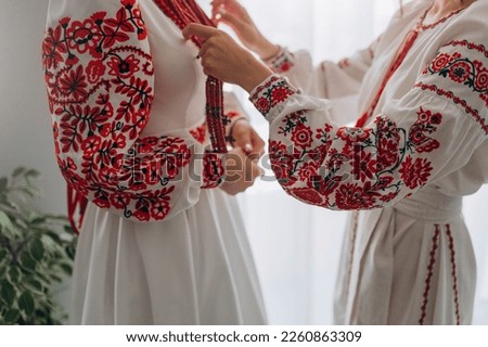 Ukrainian woman in embroidery and coral beads. Girls in Ukrainian embroidered shirts wear corals. Ukrainian traditional embroidered dress Royalty-Free Stock Photo #2260863309