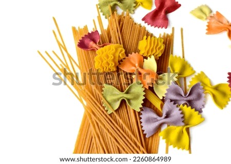 colorful italian pasta background. Different colors of farfalle bow tie and spaghetti noodles. View from above. pasta not cooked Royalty-Free Stock Photo #2260864989