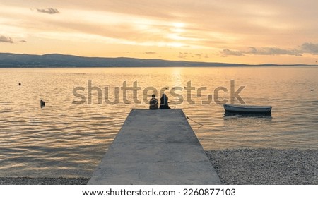 Two womens sitting waching the sunset in a croatian beach