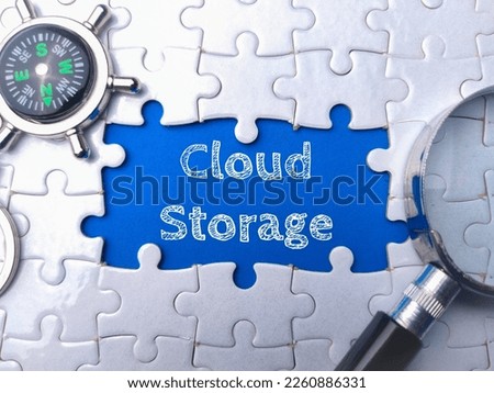 Magnifying glass and compass with the word Cloud Storage on blue background.