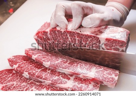 Chef cutting raw Japanese wagyu beef，Japanese Kobe beef A5 for BBQ， Royalty-Free Stock Photo #2260914071