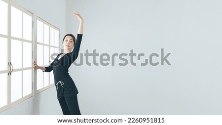 Asian woman practicing ballet in ballet studio. Royalty-Free Stock Photo #2260951815