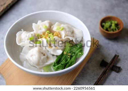 A Bowl of Wonton Soup Served on the Table, Chinese Food Consist of Dumpling Meat, Vegetable and Broth Royalty-Free Stock Photo #2260956561