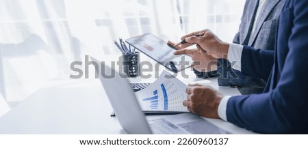 Using tablet pc, Consultant between bookkeepers and accounting lawyer consultation about asset, balance sheet, stock market statistics and yearly tax law, protect business from bribery. Royalty-Free Stock Photo #2260960137